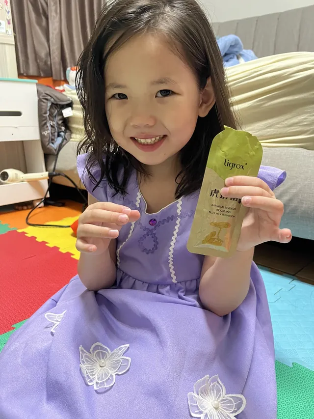 孩子手持虎奶菇養氣飲即飲包的生活照片